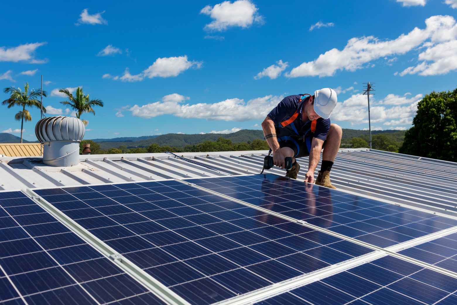 Solar Panel Technician with Drill Installing Solar Panels